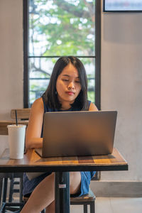 Businesswoman using laptop sitting at cafe