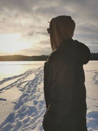 Rear view of man standing on snow covered land