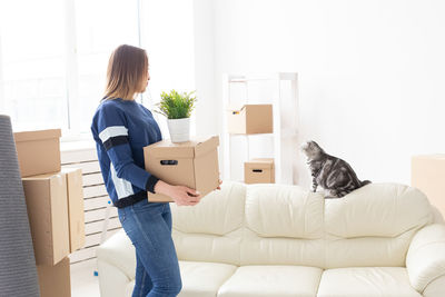 Woman carrying boxes at home