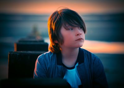 Portrait of boy looking at sea against sky