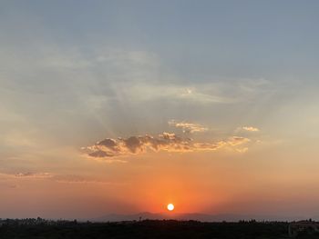 Sun streaming through clouds during sunset