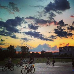 Cars parked against cloudy sky at sunset