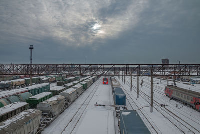 Winter view of the railway station with electric trains and freight cars on the tracks