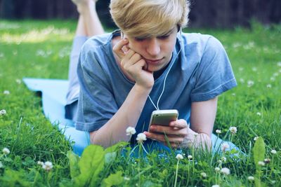 Teenage girl using mobile phone in field