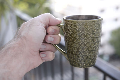 Close-up of hand holding coffee cup