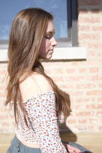 Mid adult woman standing against wall