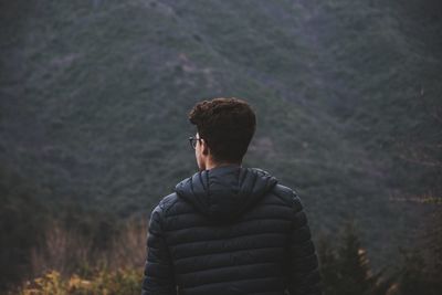 Rear view of man standing against mountain