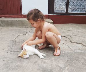 Full length of shirtless man sitting in cat