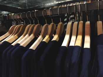 Close-up of clothes hanging in row on coathangers at shop