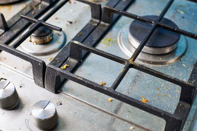 Dirty stove top with oil splatters, fat stains and food leftovers. unclean steel kitchen cooktop