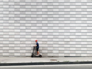 Side view of man walking against wall