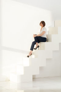 Thoughtful businesswoman sitting on steps in office