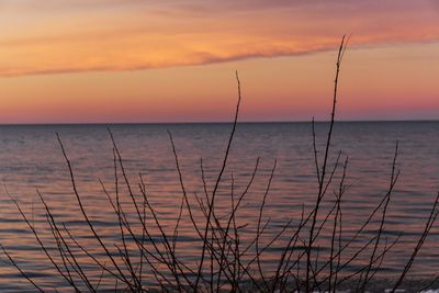 Scenic view of sea against romantic sky at sunset