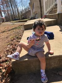 Portrait of cute girl sitting outdoors