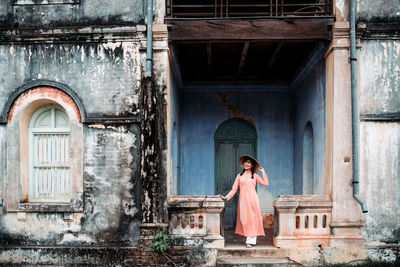 Woman standing at entrance of historic building