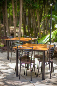 Empty chairs and tables at sidewalk cafe