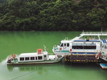 Boats moored on river against trees