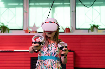 Vr game and virtual reality. kid girl gamer fun playing on futuristic simulation video shooting game