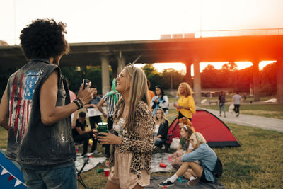 Man and woman talking while having fun with friends at music event