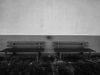 Empty bench on table against wall