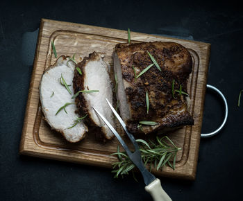 Baked piece of pork meat in spices on a wooden board, cut into pieces. eye of round roast steak