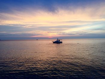 Silhouette boat in sea against sky during sunset