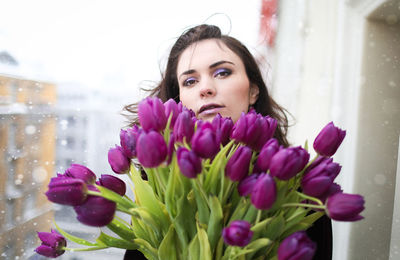 Portrait of woman against purple flowering plants