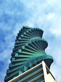 Low angle view of modern building against cloudy sky