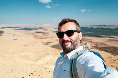 Portrait of man wearing sunglasses against sky