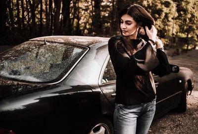 Mid adult woman holding camera while sitting in car