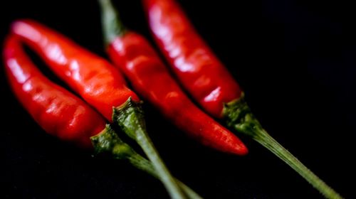 Close-up of red chili peppers against black background