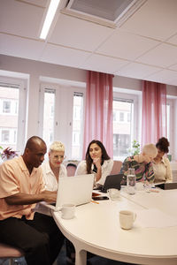 Coworkers sitting at business meeting and talking to each other