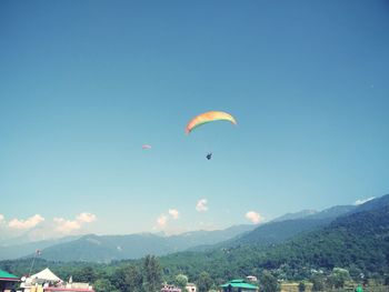 People paragliding over mountain against sky