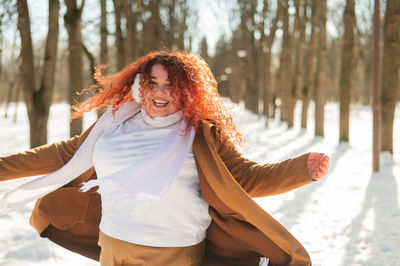 Carefree woman playing in snow