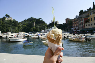 Woman holding ice cream cone on frozen lake