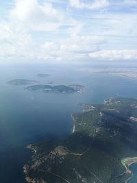 Aerial view of sea and cityscape against sky