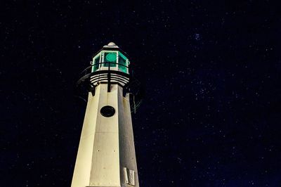 Low angle view of lighthouse against sky at night