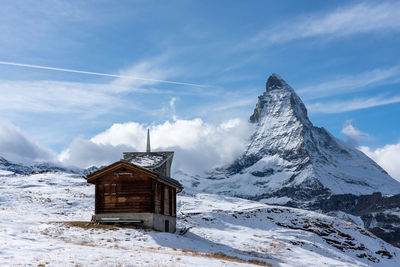 Built structure on snow covered land against sky