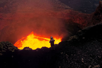 High angle view of person standing by active volcano