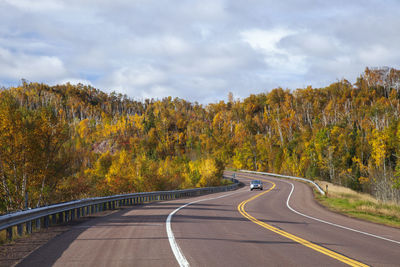 Road amidst trees against sky