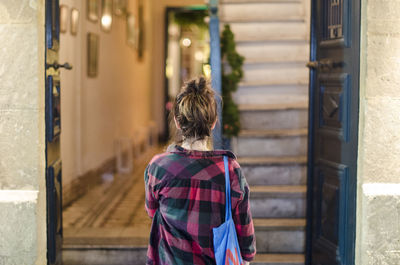 Rear view of girl standing at entrance of restaurant