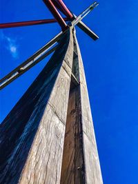 Low angle view of wind turbine against blue sky