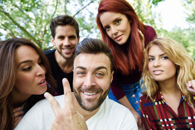 Portrait of smiling young man with friends at park