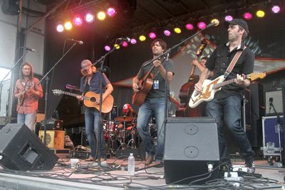 People playing guitar at music concert