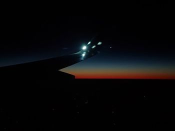Airplane wing in sky at night