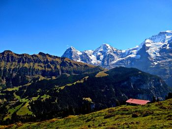 Scenic view of snowcapped mountains against clear blue sky