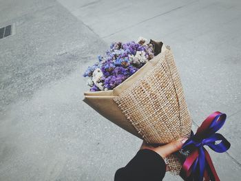 Cropped hand of woman holding flower bouquet