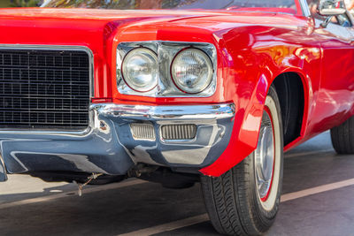 The front of a red classic car or muscle car in the street