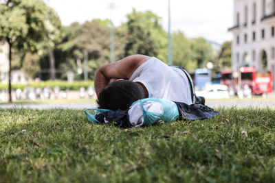 Rear view of man lying on grassy field