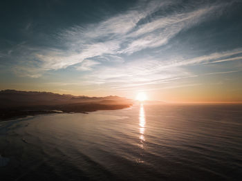 Scenic view of sea and mountains against sky during sunset